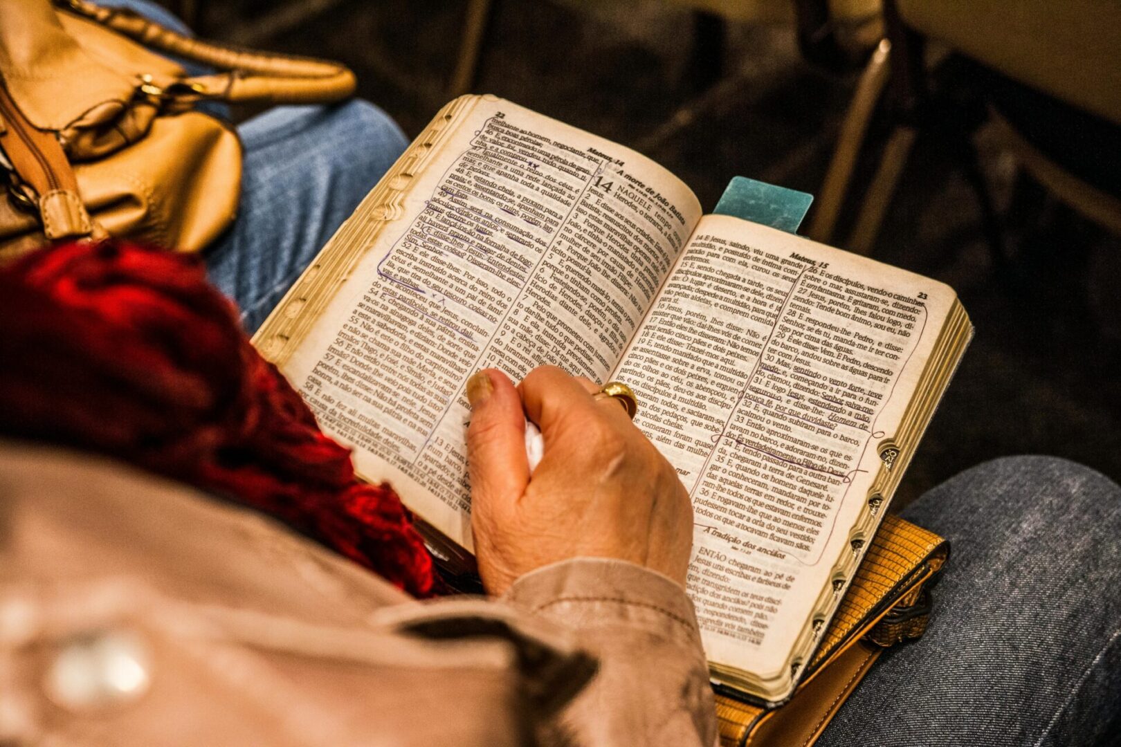 A person is reading the bible on their lap.