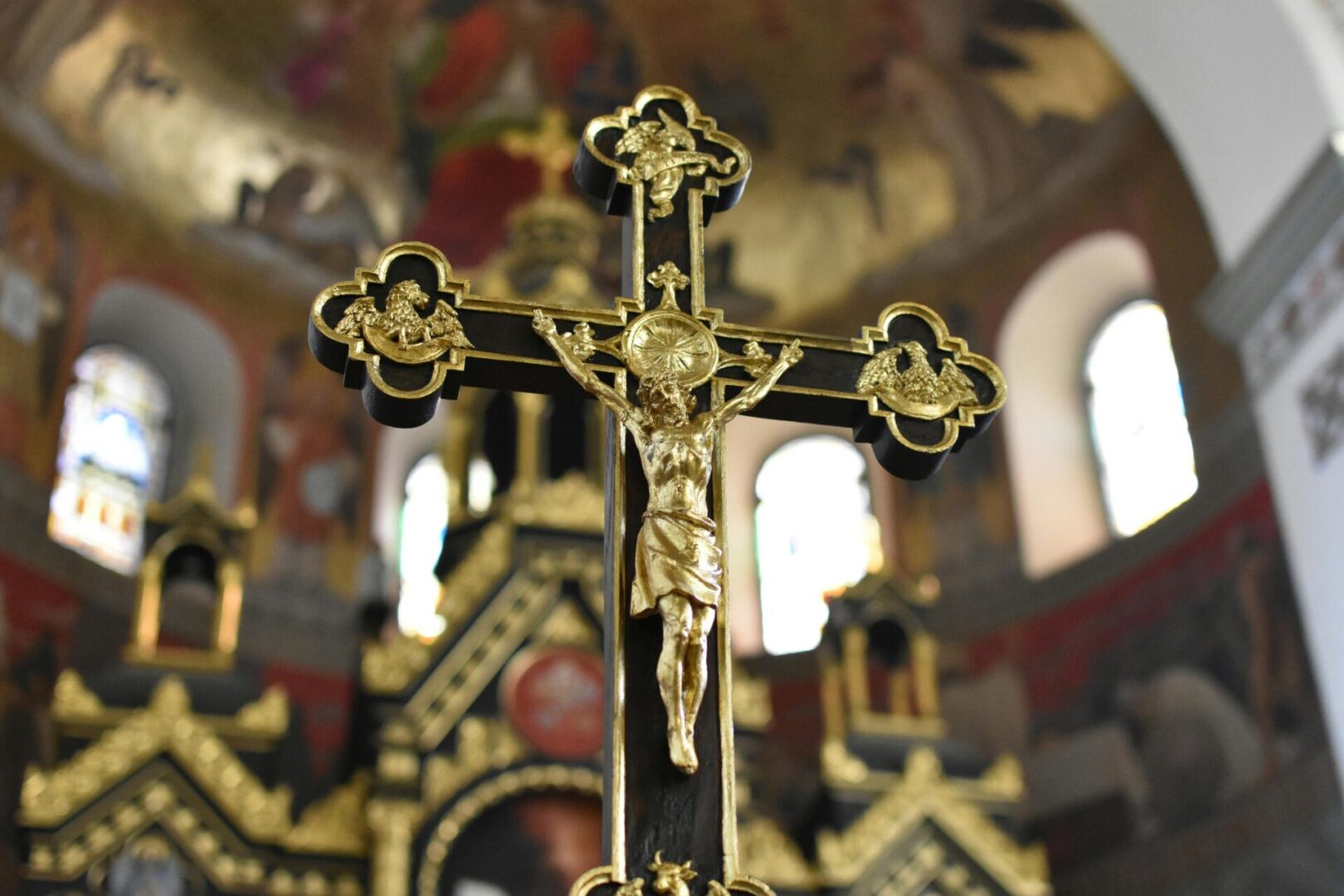 A cross with gold paint and a crucifix on it.